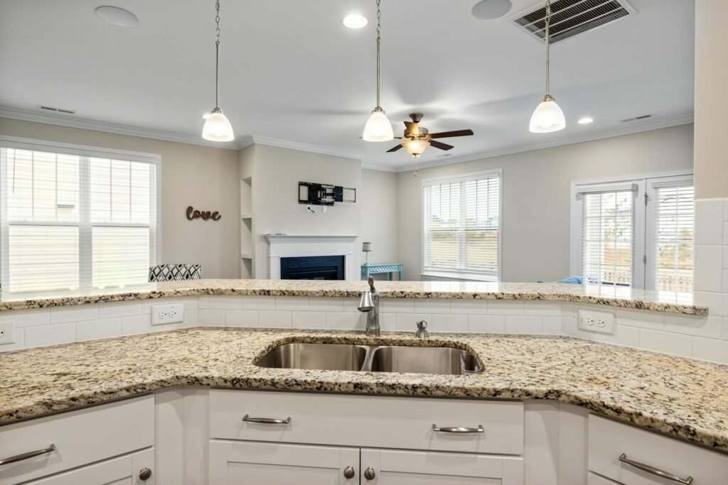 A kitchen at night with dishes on the counter under bright overhead lights