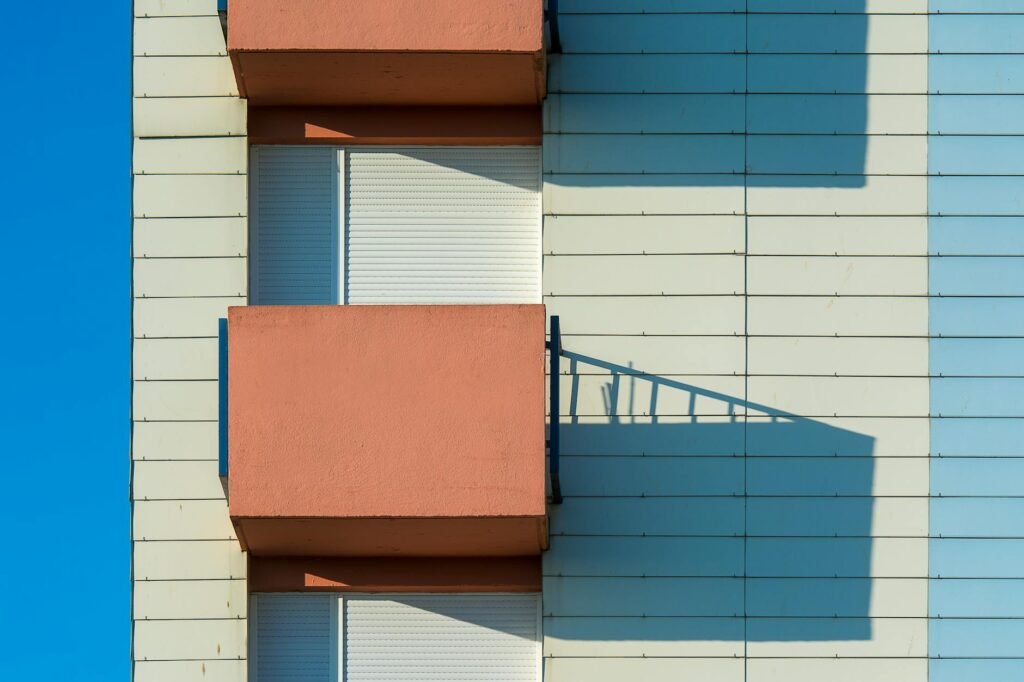 A small apartment balcony in the morning with daylight and a chair