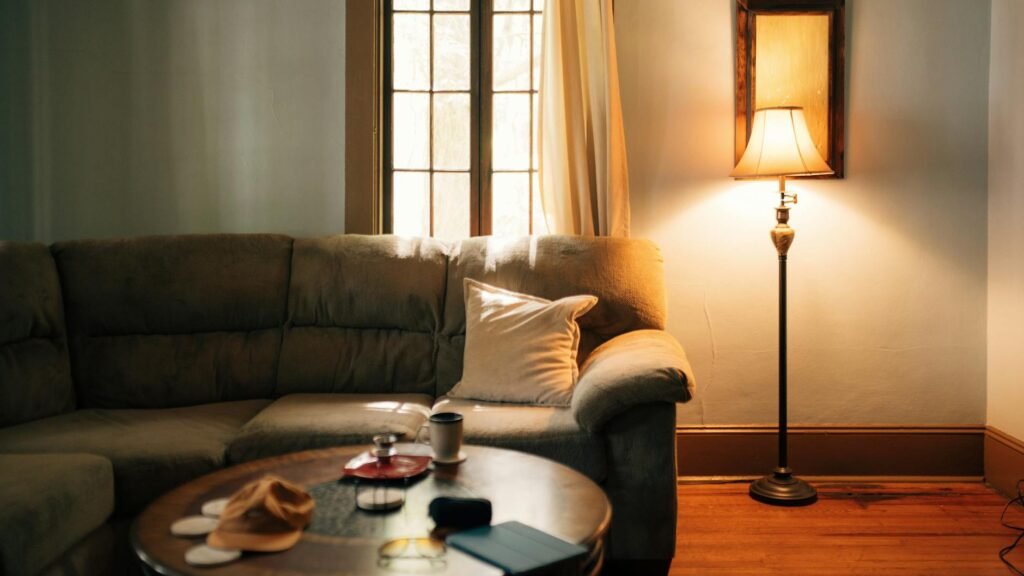 A softly lit living room at night with one lamp on and the ceiling lights off