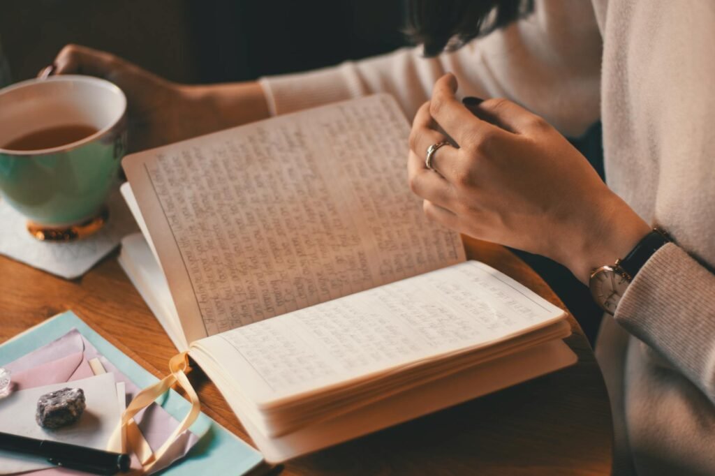 A person recording sleep notes in a notebook at a table