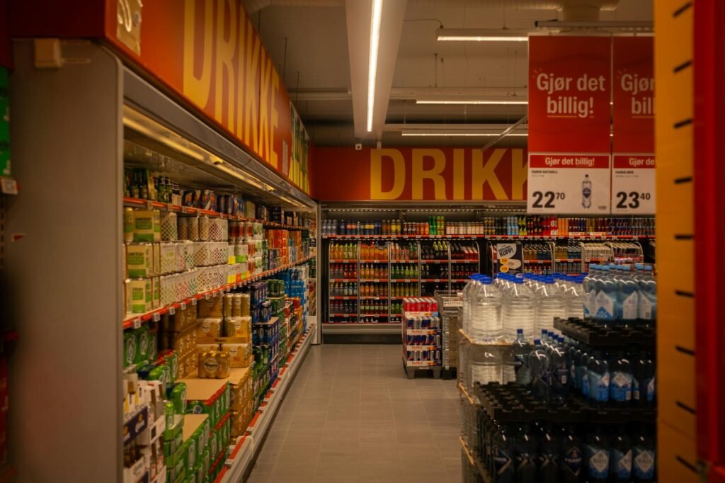 A shopper checking a beverage label in a grocery store aisle