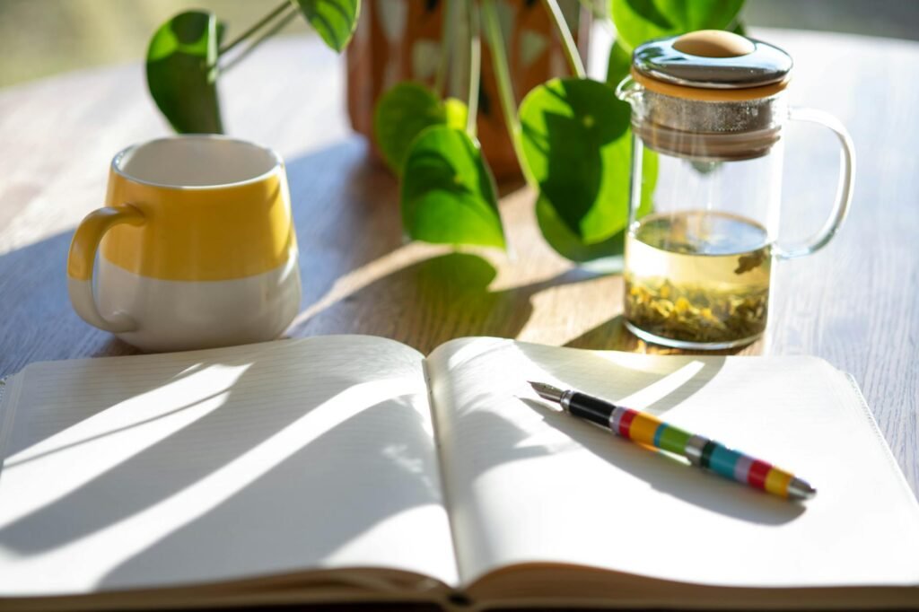 A simple sleep log on a bedside table with a pen, mug, and glass of water.