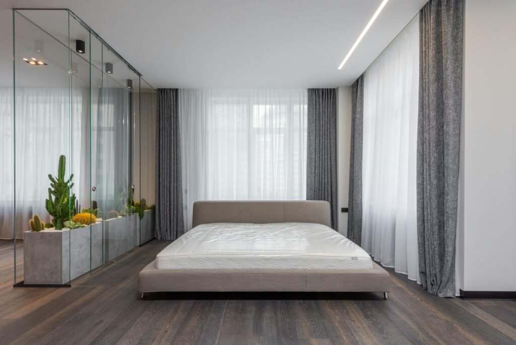A simple, dark bedroom with blackout curtains and minimal visual clutter.