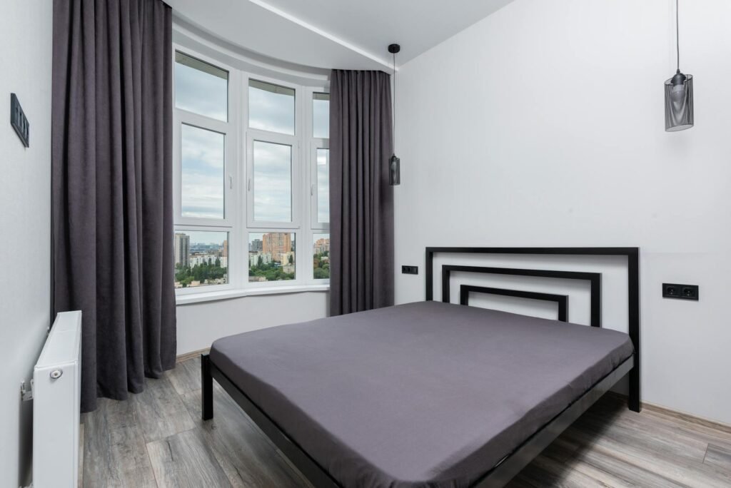 A dark bedroom with blackout curtains and soft lighting.