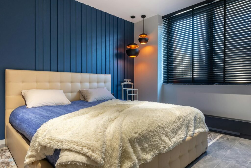 A bedroom window with simple blackout shades and curtains