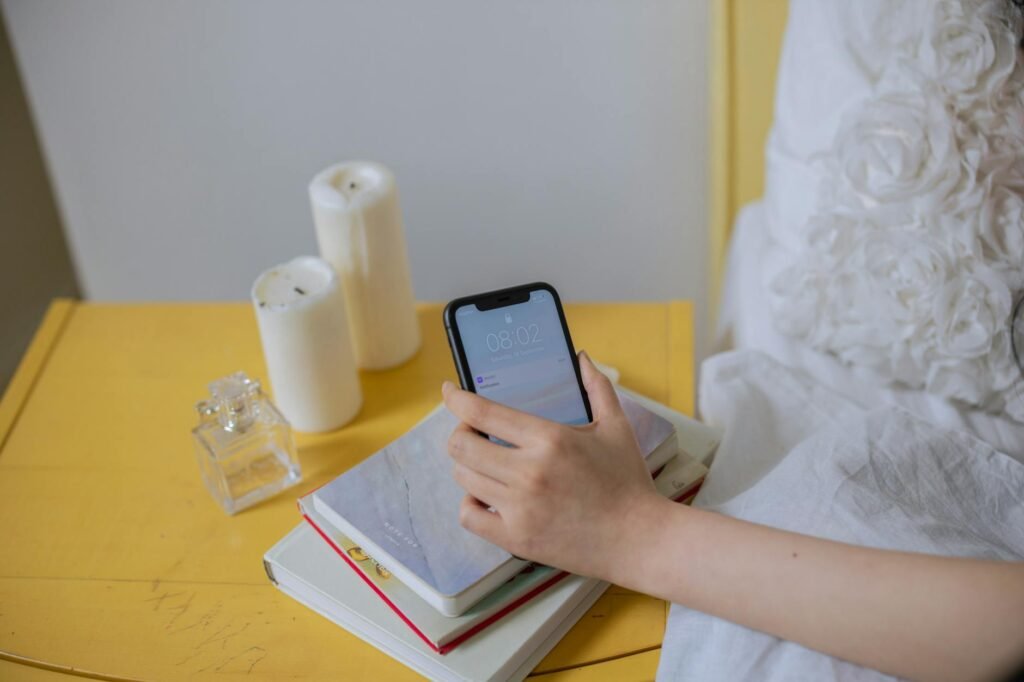 An alarm clock next to a paper planner and glasses on a tidy nightstand.