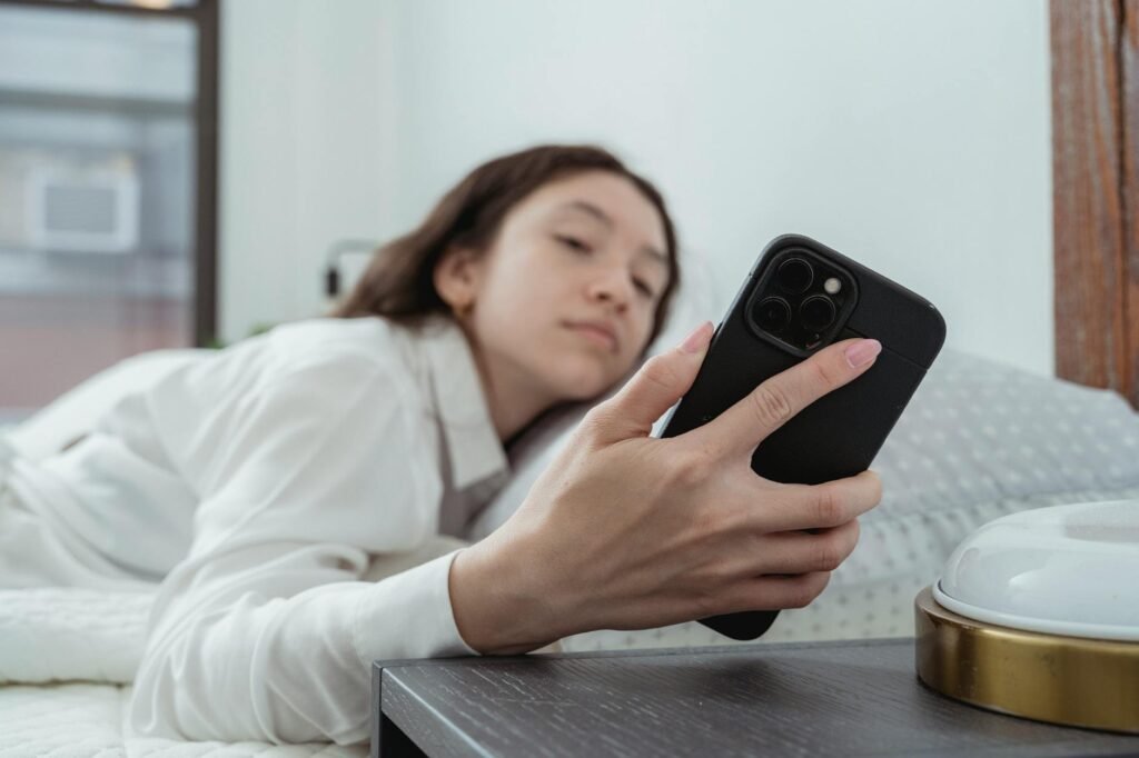 A person setting a bedtime alarm while reviewing a planner in the evening.