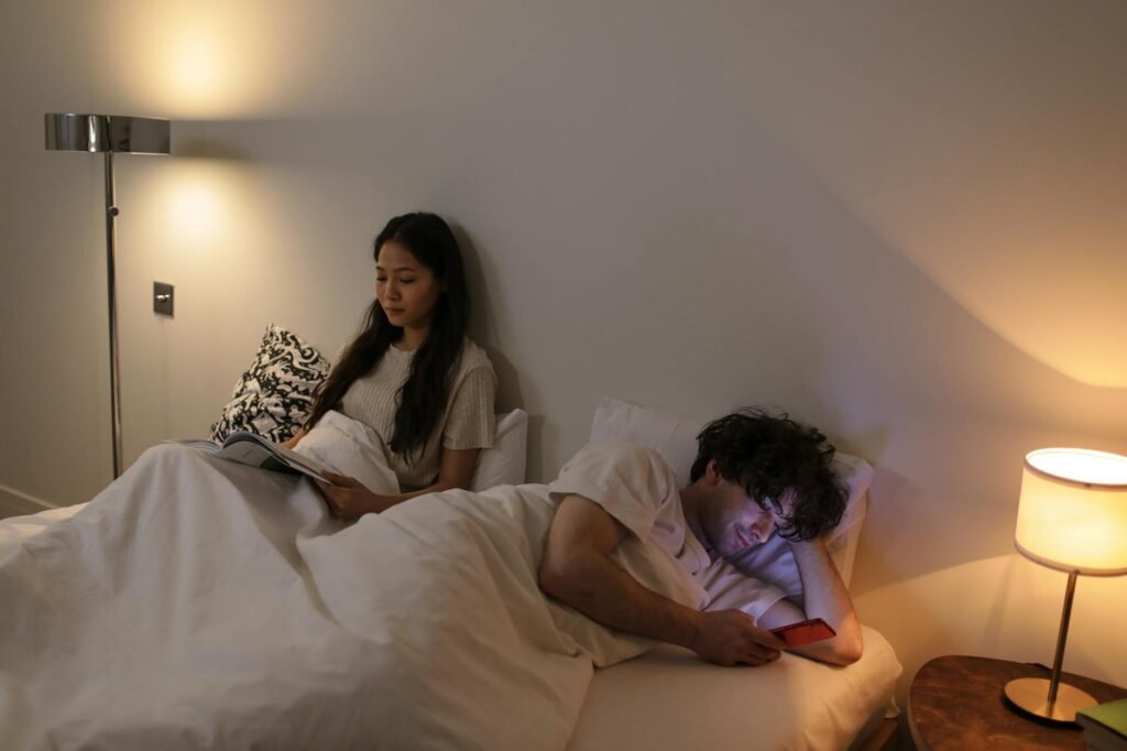 A person reading a book in warm low light before sleep