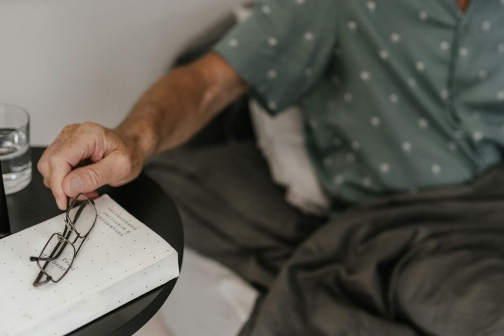 A bedside table set up for sleep with an eye mask, earplugs, and a book