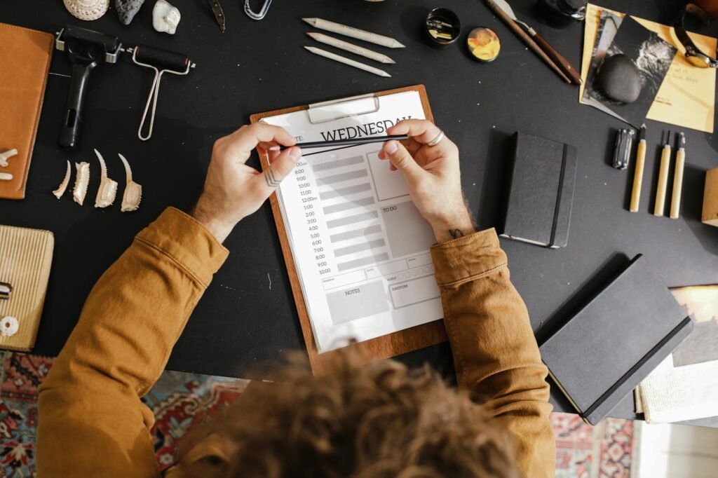 A printed sleep diary and pen on a desk next to a glass of water.