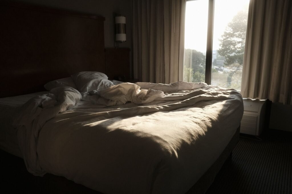 Morning sunlight coming through partially opened curtains in a tidy bedroom.