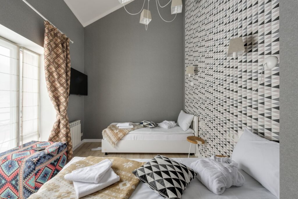 A small bedroom with a lidded hamper and tidy bedding storage